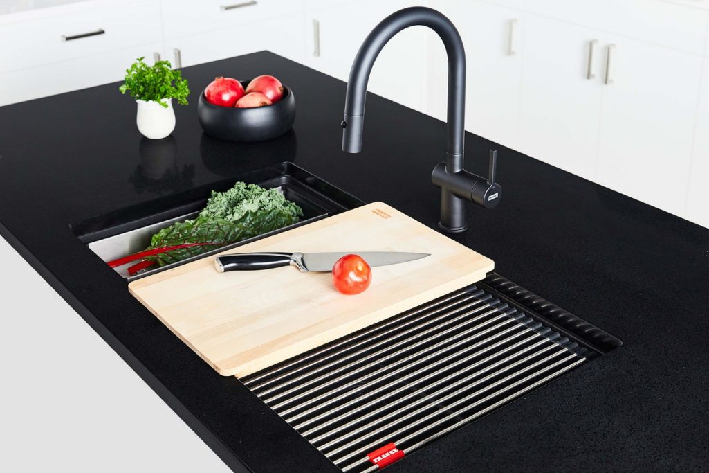 Vegetables being prepped on sink accessories  over a Franke Maris granite sink 