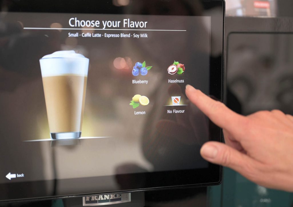 Franke Coffee Systems, coffeee machine screen close-up, choosing flavors, hand choosing flavored coffee