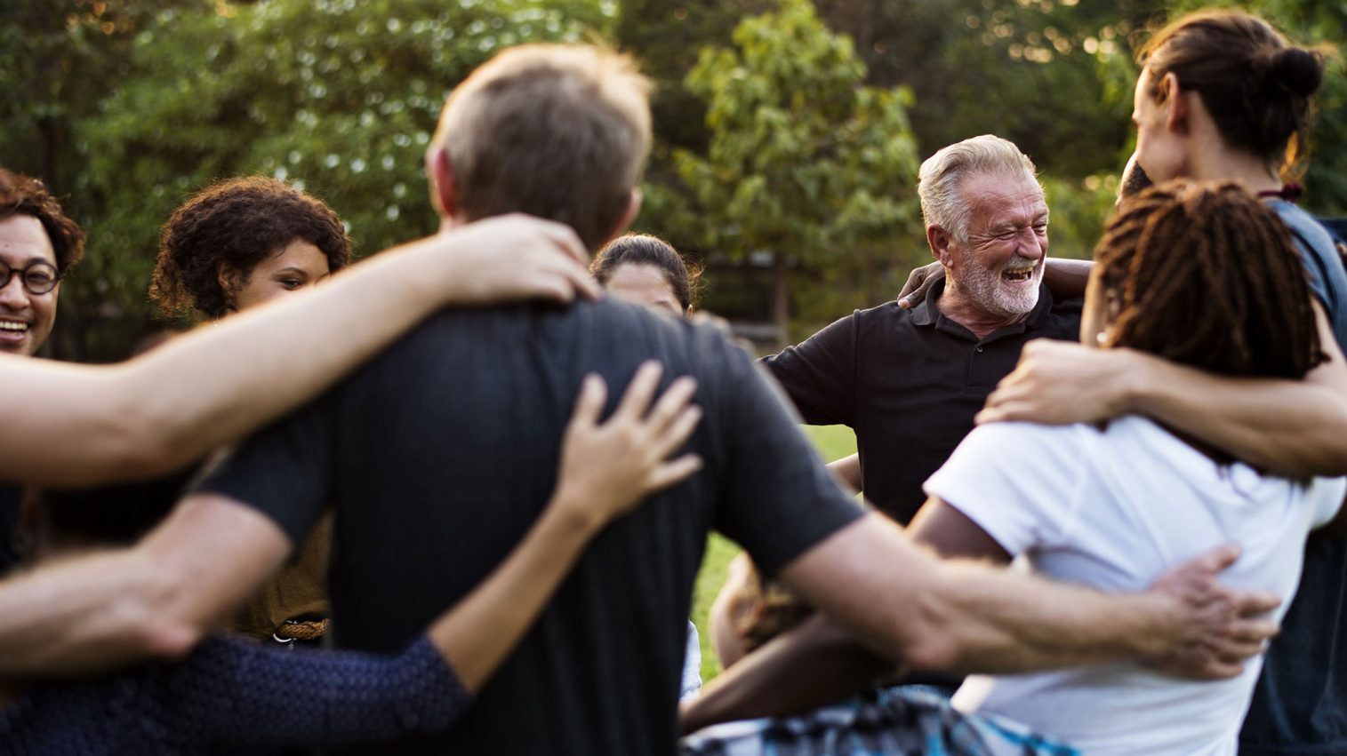 group of people standing in a circle in a park