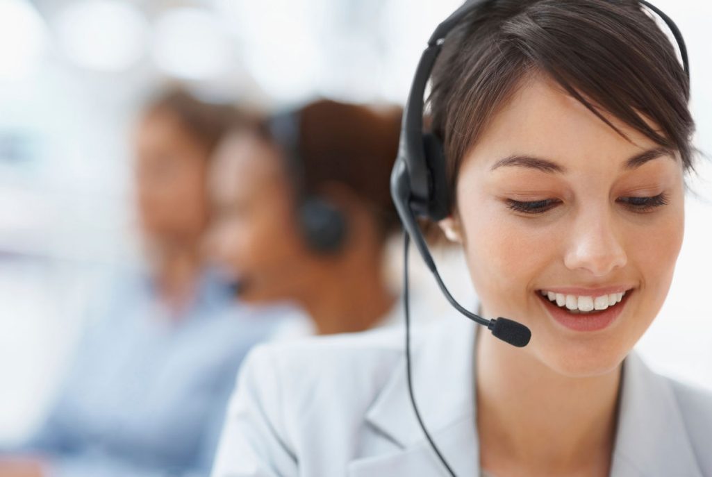 Customer representative with headset smiling during a customer call