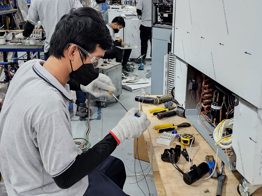 young electrical engineering technician assembling a machine