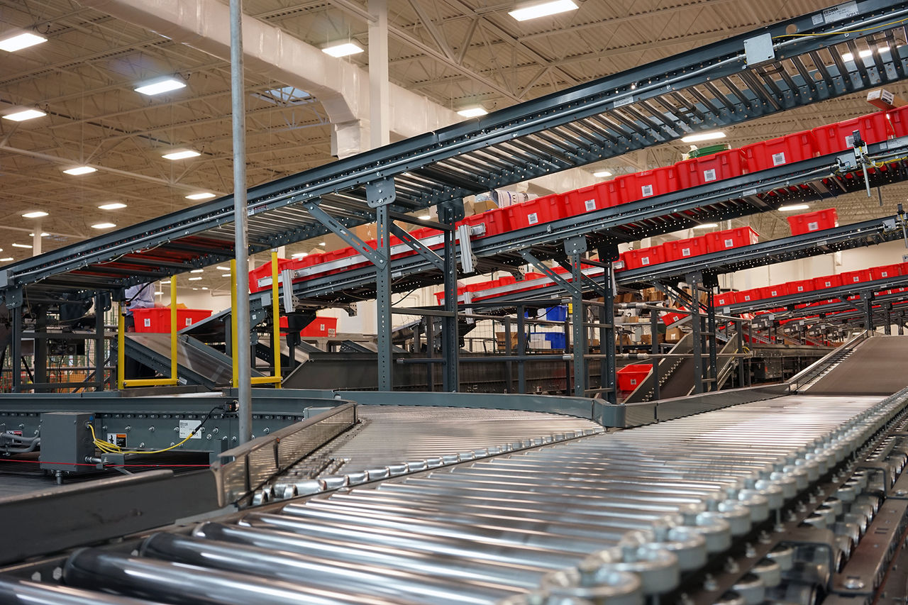 A maze of conveyors moves red tote boxes container orders from various locations in a Franke warehouse