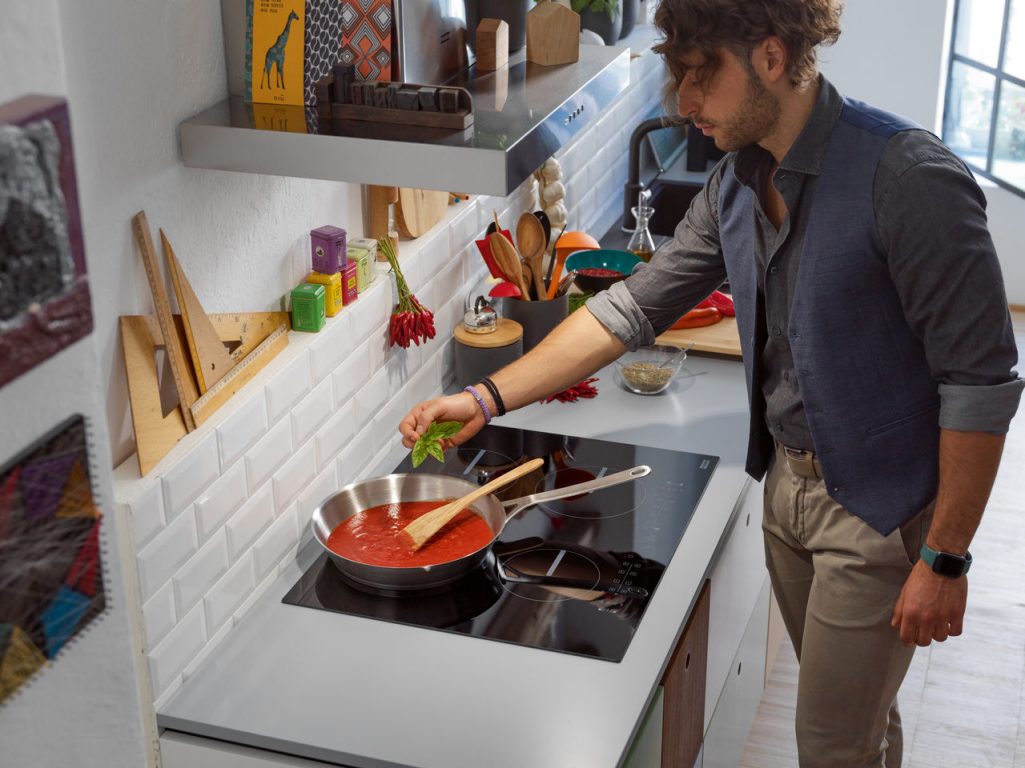 Hombre preparando una sopa de tomate en una placa Smart de Franke