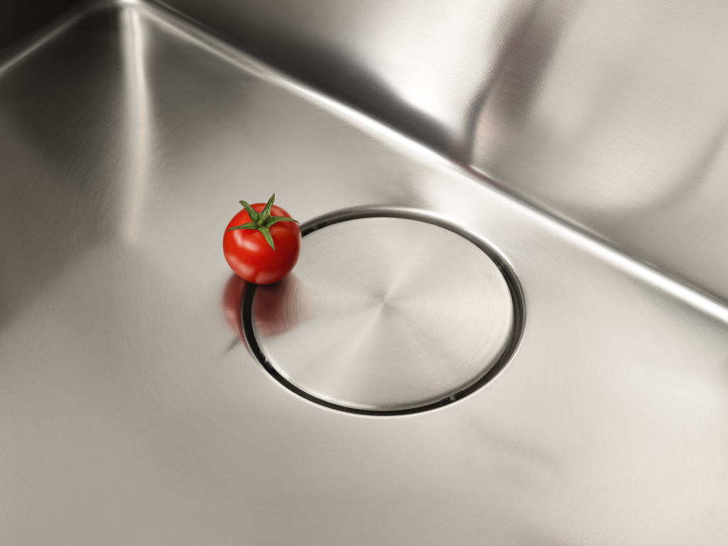 A Tomato next to the waste cover of the Franke Mythos Bowl Sink