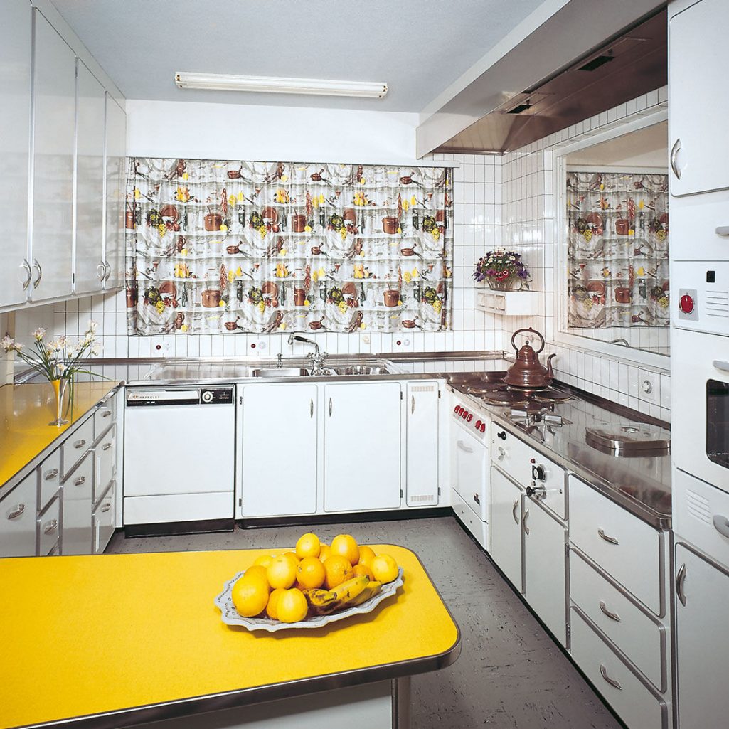View of a steel kitchen with a bowl of fruits on the table