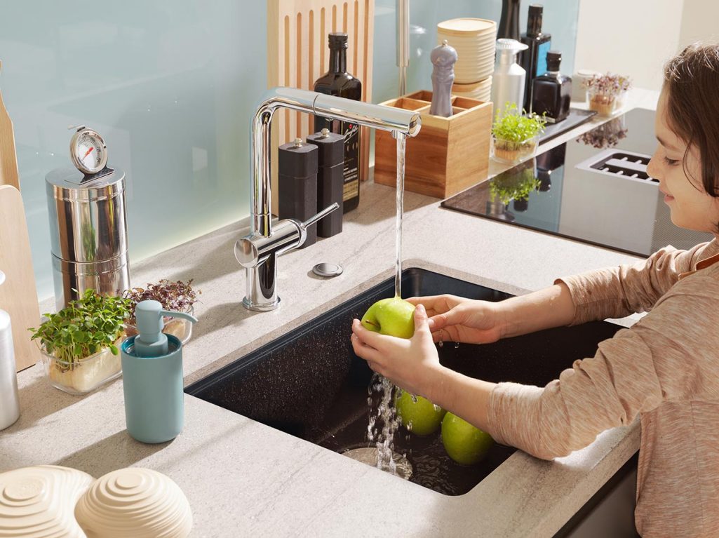 Child washing green apples in a Maris undermount granite sink  using a Franke Active faucet